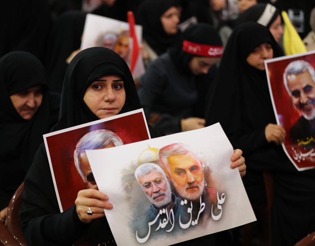 Manifestante carrega cartaz com fotos de Soleimani e comandante Abu Mahdi al-Muhandis