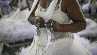 Nilcéa amarra a base da fantasia antes de entrar no vestido armado — Foto: Guito Moreto/Agência O Globo