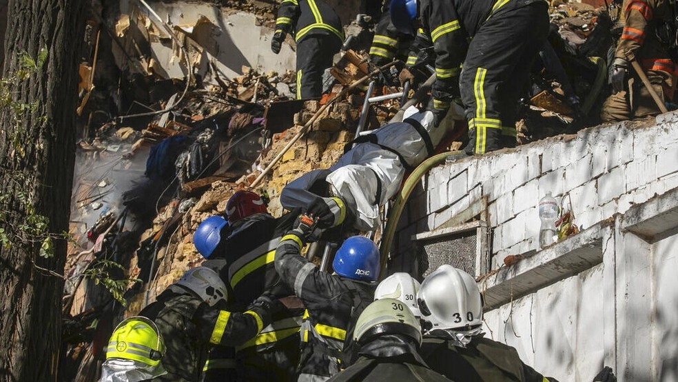 Os bombeiros carregam o corpo de uma pessoa morta depois que um drone atingiu um prédio em Kiev, Ucrânia, na segunda-feira, 17 de outubro de 2022 — Foto: AP - Yevhenii Zavhorodnii