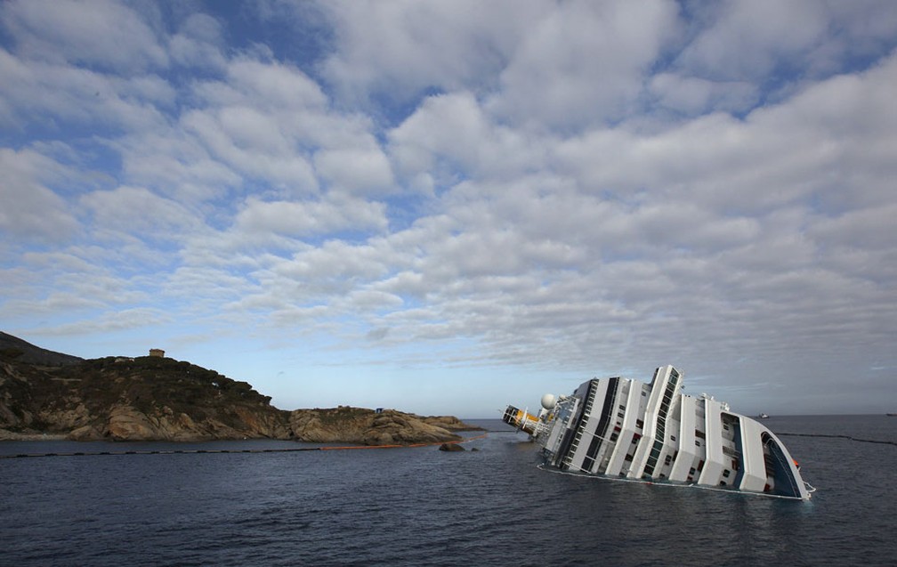 O transatlântico Costa Concordia tombado na costa da ilha italiana de Giglio, no 10º dia após o acidente, em 2012 — Foto: Tony Gentile/Reuters