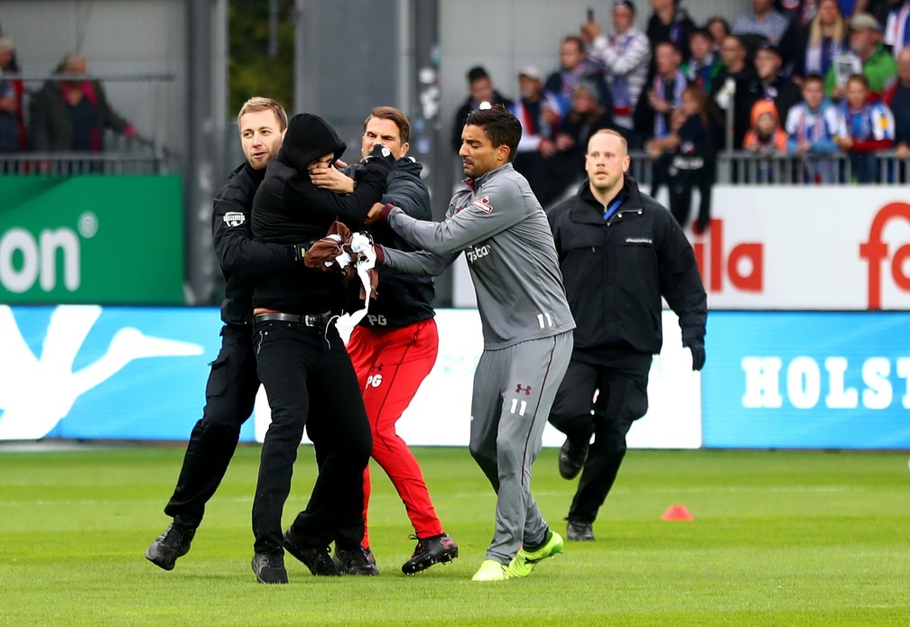 Jogador do St. Pauli, de cinza, ajuda a segurar um dos invasores (Foto: Getty Images)