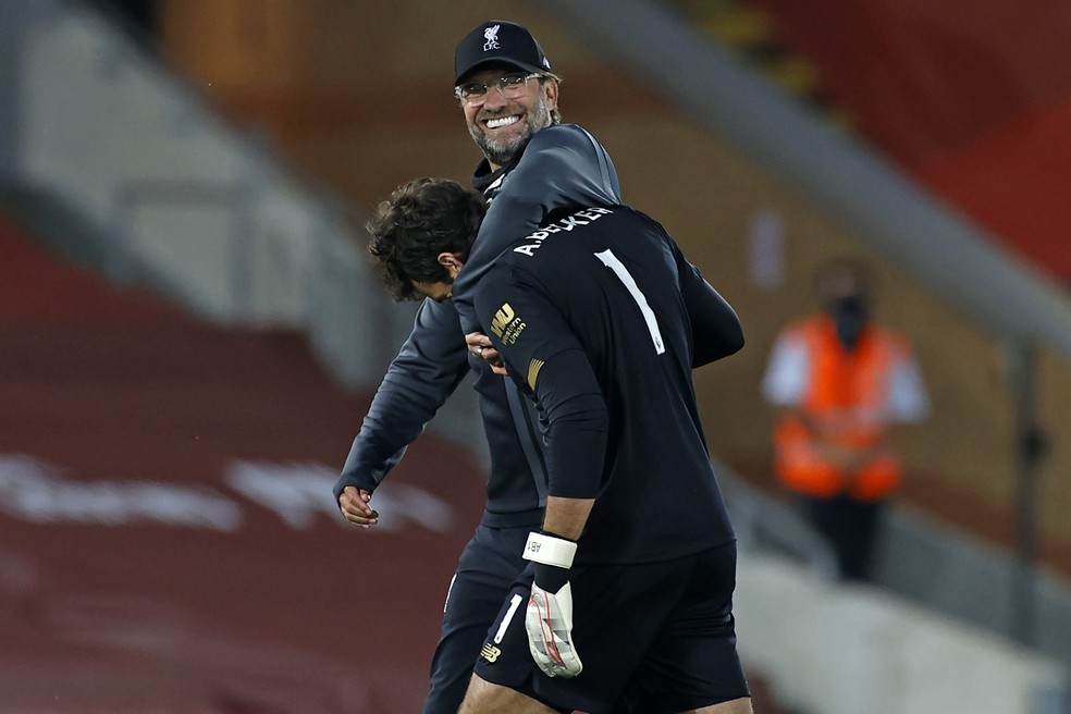 O técnico Jurgen Klopp abraça o goleiro Alisson após a goleada sobre o Crystal Palace: Liverpool está a um passo do título inglês — Foto: Phil Noble/AFP