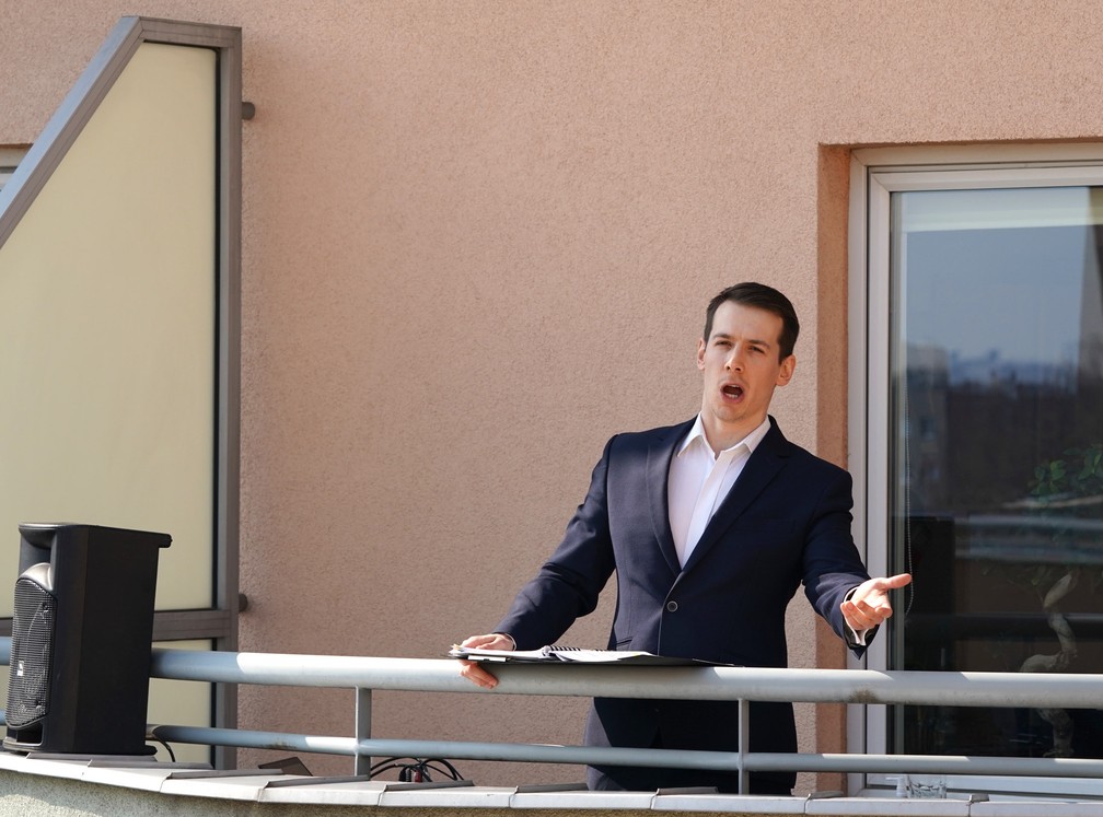 O cantor de ópera Michal Janicki se apresenta na varanda de seu apartamento e canta para seus vizinhos em Varsóvia, na Polônia, em 28 de março, durante isolamento para conter o novo coronavírus  — Foto:  Janek Skarzynki/AFP