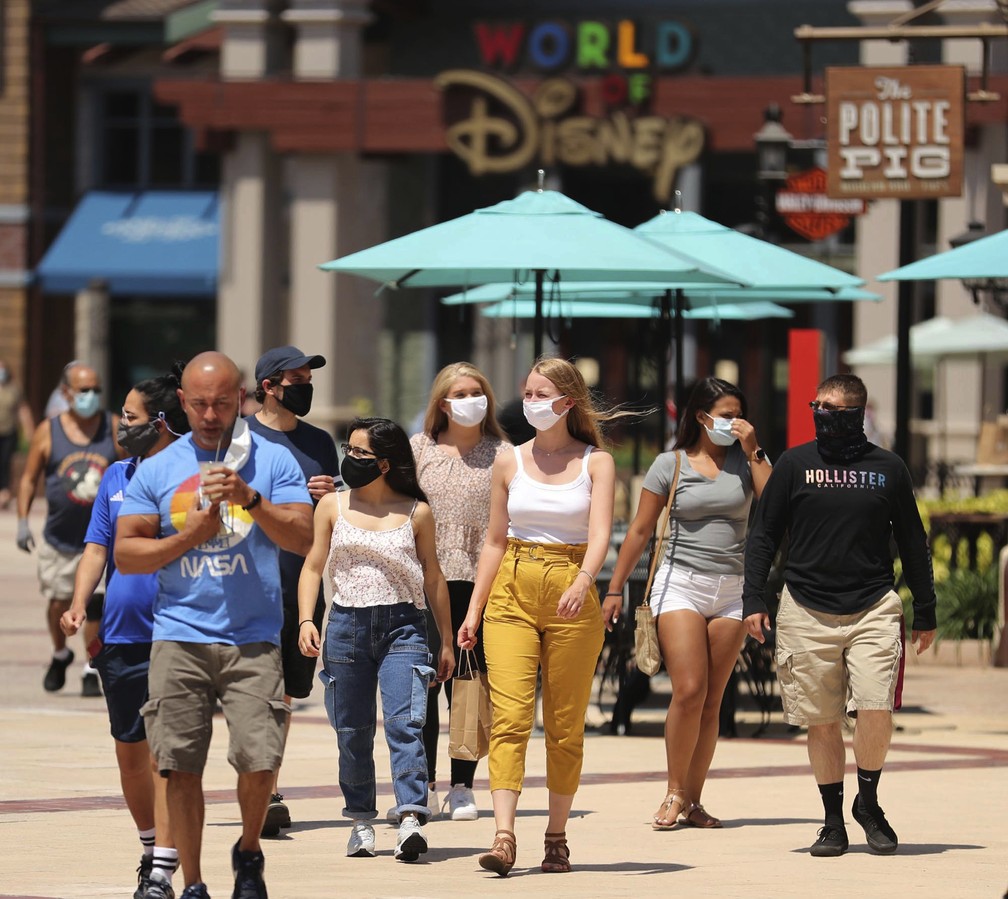 Pessoas andam por Disney Springs, em Orlando, na Flórida, no dia 20 de maio, depois da abertura de restaurantes e locais de compras em Walt Disney World. — Foto: Stephen M. Dowell/AP
