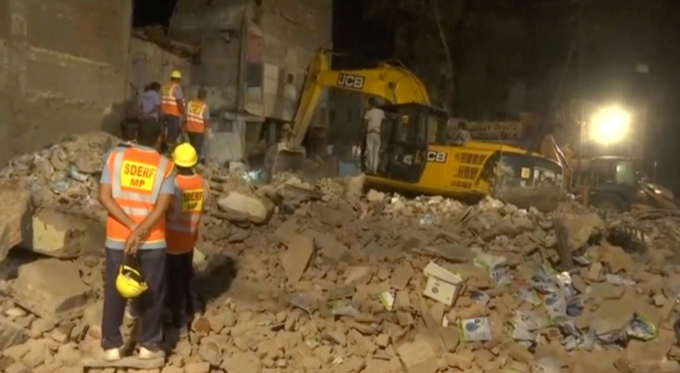 Homens escavam escombros apÃ³s queda de prÃ©dio em Indore, na Ã­ndia (Foto: ANI/via REUTERS)
