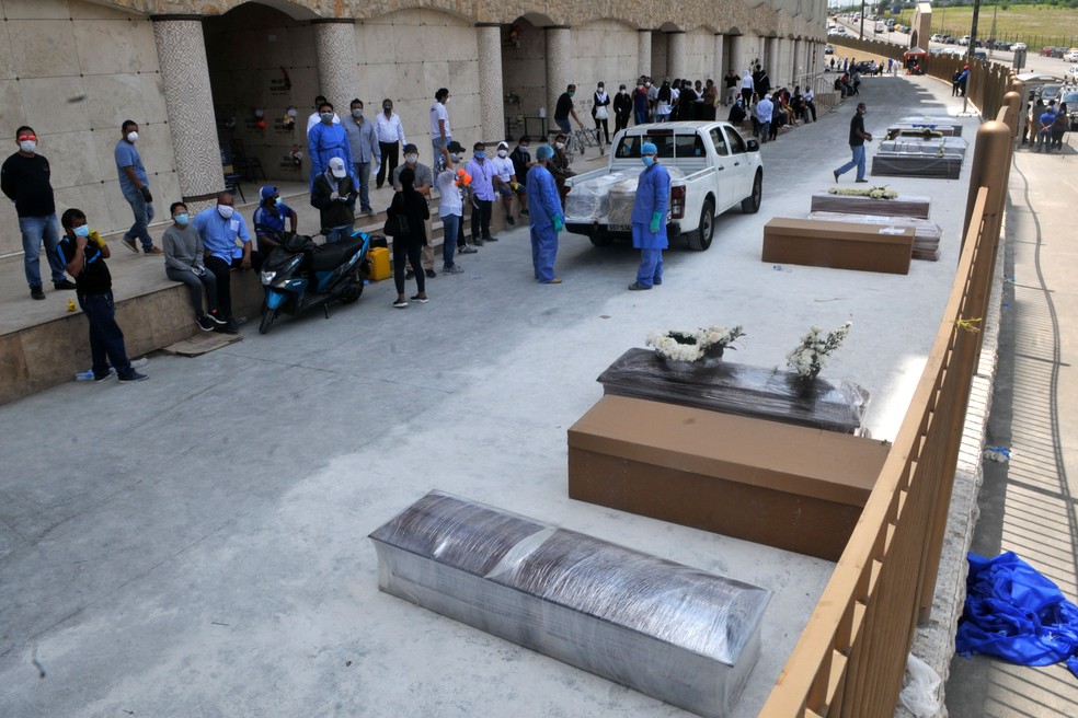 Pessoas esperam do lado de fora de cemitério de Guayaquil, no Equador, para enterrar familiares em caixões e caixas de papelão, em imagem de 2020 — Foto: Jose Sanchez / AFP