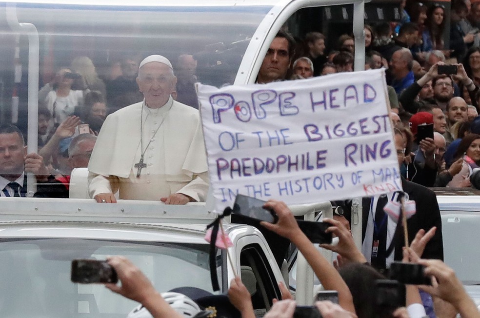 Durante visita a Dublin, na Irlanda, neste sábado (25), o Papa Francisco para por um cartaz que alude a casos de abuso sexual cometidos por membros da igreja católica (Foto: Matt Dunham/AP)