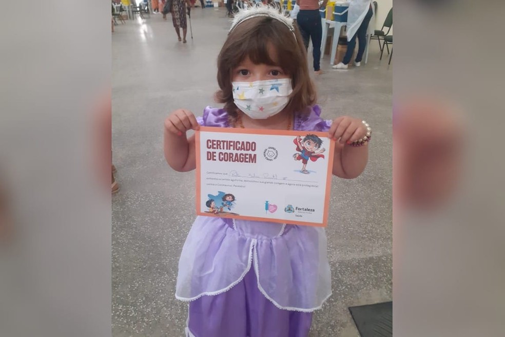 Pietra posa com certificado de coragem após receber vacina contra Covid, em Fortaleza. — Foto: Arquivo pessoal