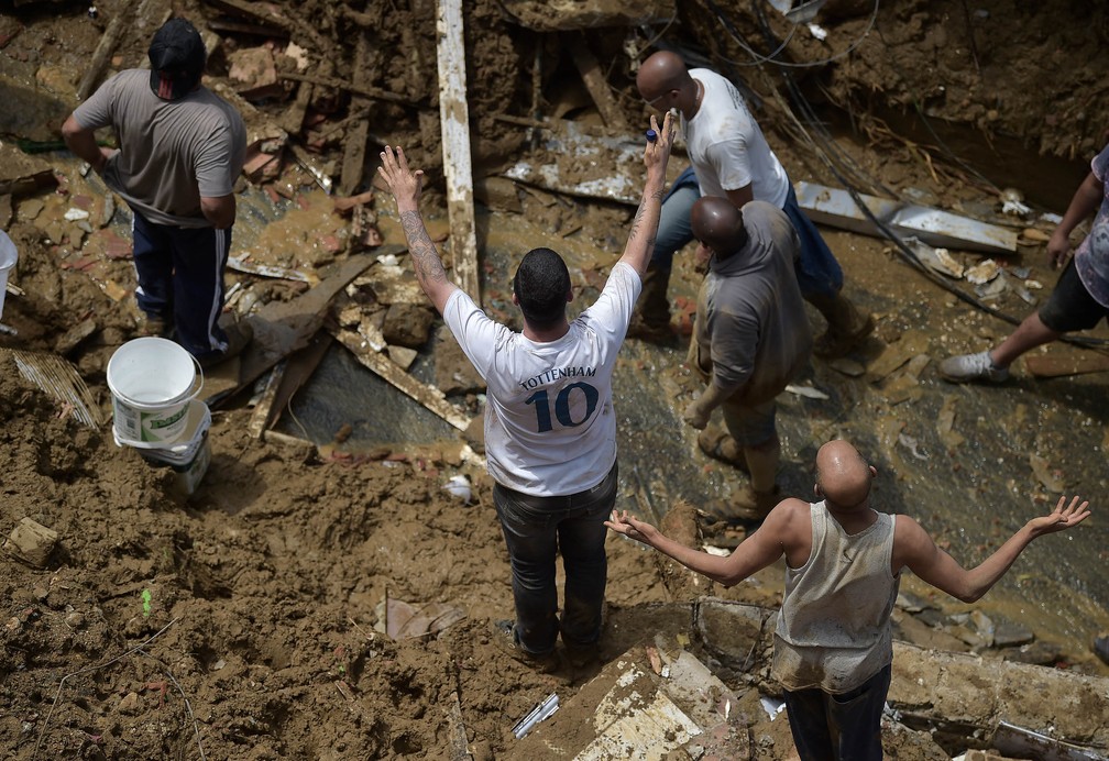 Moradores fazem buscas por sobreviventes após deslizamento no Morro da Oficina, em Petrópolis (RJ) — Foto: Carl de Souza/AFP