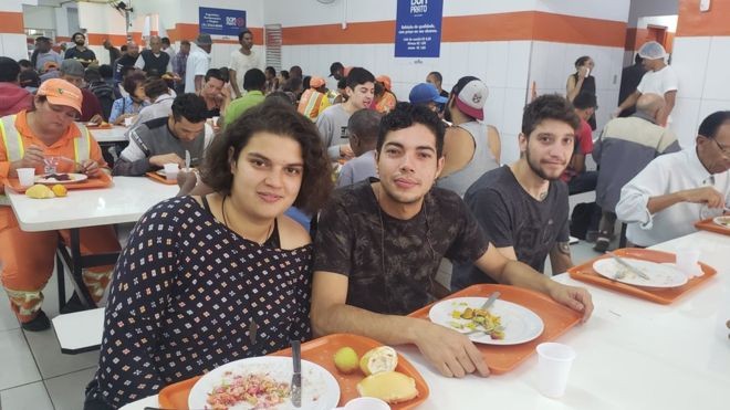 BBC: Isis, 22, ao lado do amigo Kevin, 28: sem renda, ela junta as moedas para almoçar todos os dias a R$ 1 (Foto: BBC NEWS BRASIL VIA BBC)