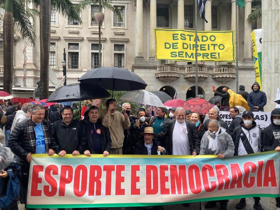 O ex-locutor Osmar Santos, a 'Voz das Diretas', o jornalista Juca Kfouri e colegas seguram a faixa 'Esporte e Democracia' durante o ato — Foto: Rafael Rigato