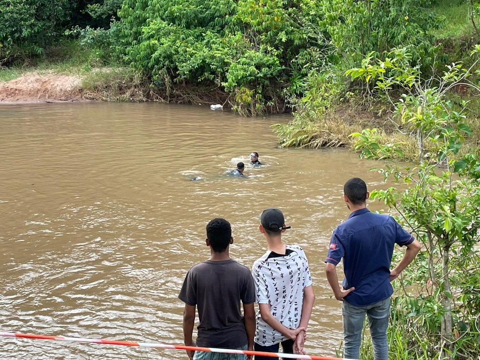 Amigos aguardam na beira de córrego equipe encontrar adolescente que morreu — Foto: Lorena Segala 