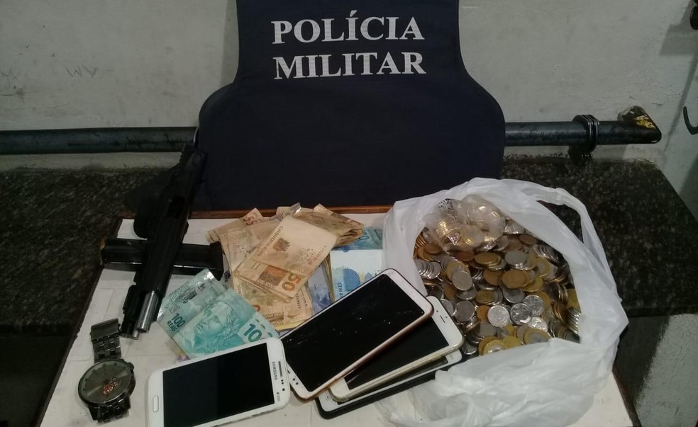 A polícia apreendeu uma arma, um carro e mais de R$ 6 mil, um relógio e quatro celulares da vítima. — Foto: Divulgação/ Polícia Militar