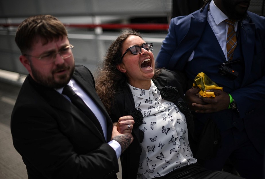 Seguranças retiram à força um membro do grupo ativista holandês 'Milieudefensie' durante uma manifestação do lado de fora do ExCeL, em Londres, durante a Reunião Geral Anual da multinacional de petróleo e gás Shell