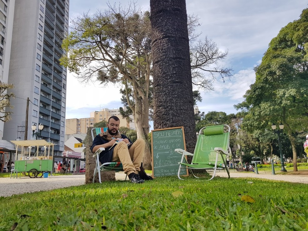Igor se oferece para escrever de cartas de graça em praça no Centro de Curitiba — Foto: Natalia Filippin/G1