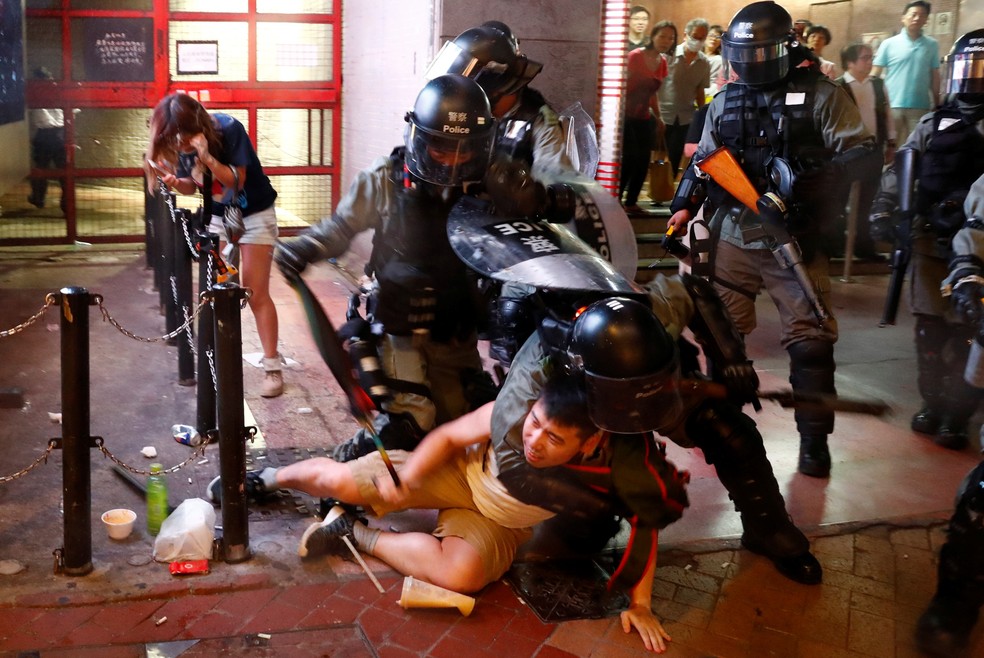 Manifestante é detido por policiais durante manifestação em Hong Kong neste sábado (02) — Foto: Thomas Peter/Reuters
