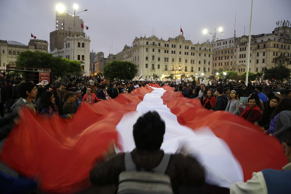 Manifestantes estendem bandeira com as cores nacionais do Peru em protesto contra corrupção no Judiciário do país (Foto: AP Photo/Martin Mejia)