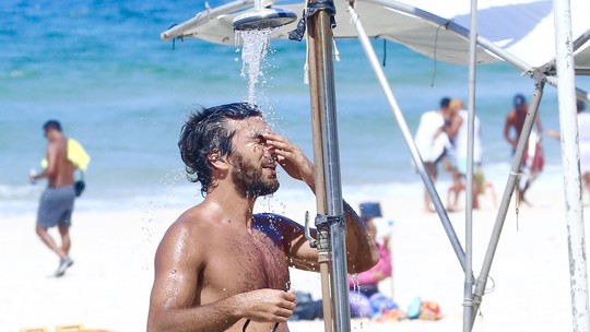 Sem Deborah Secco, Hugo Moura joga futevôlei e toma ducha em praia, no Rio