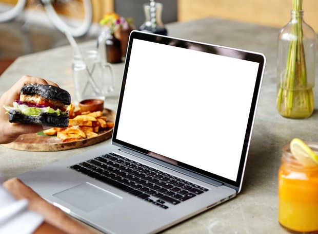 Comer em frente ao computador é comum, mas é preciso ter cuidado para não deixar cair alimentos e líquidos sobre o teclado (Foto: Freepik/CreativeCommons)