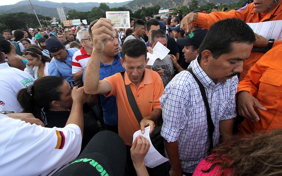  Venezuelanos mostram documentos ao cruzar fronteira com Colômbia  (Foto: George Castellanos/AFP)