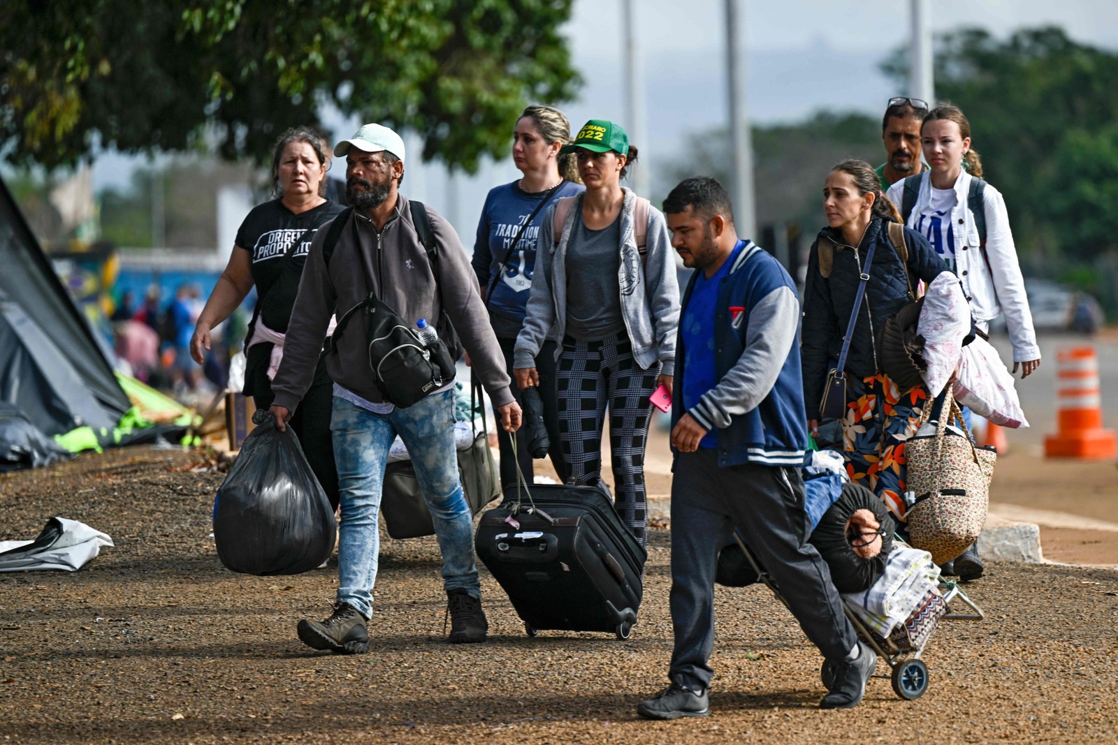 Apoiadores do ex-presidente Bolsonaro deixam a área do acampamento. — Foto: Mauro Pimentel / AFP