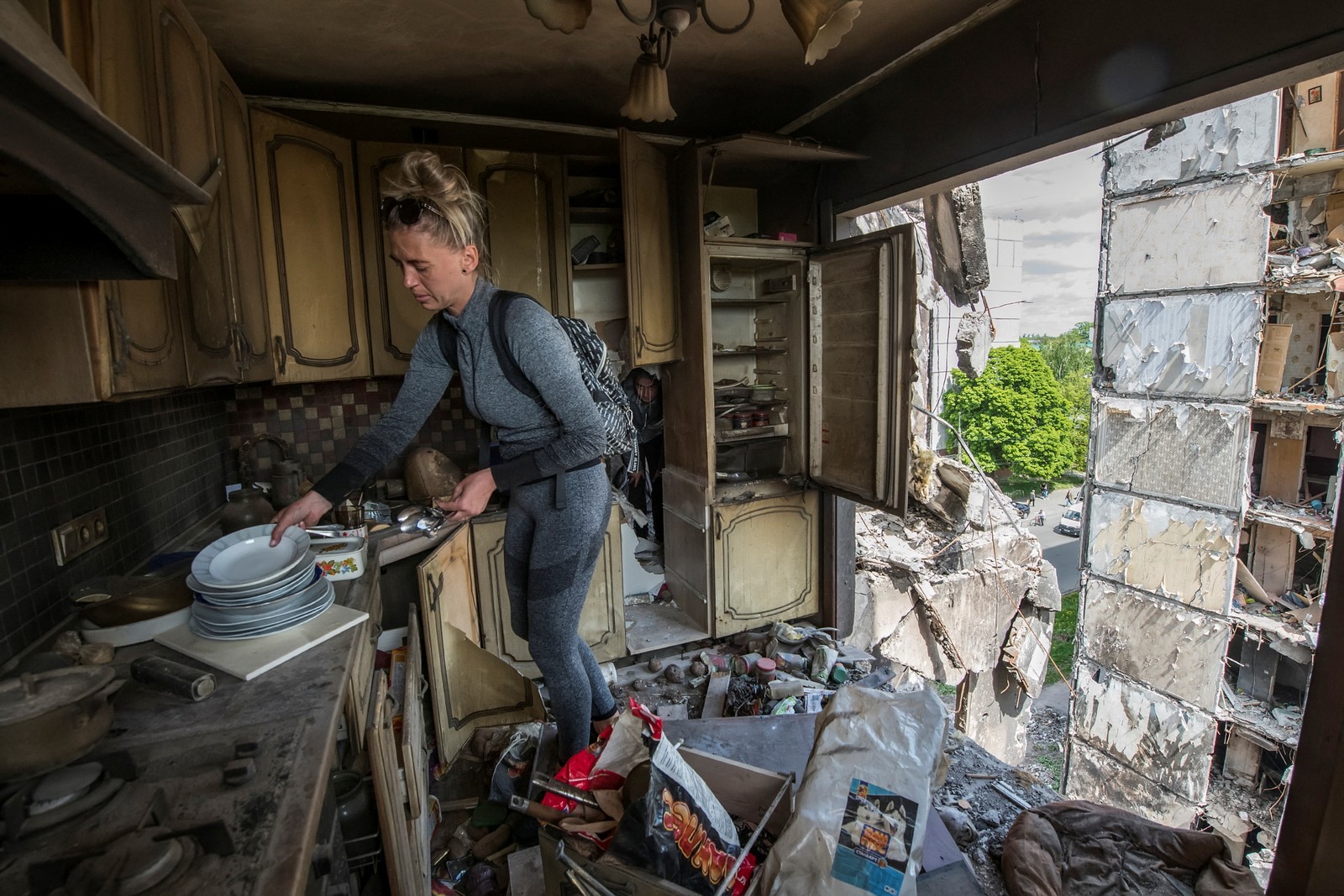 Moradora recolhe itens da cozinha de seu apartamento dentro de um prédio residencial destruído durante a invasão da Ucrânia pela Rússia na cidade de Borodianka, na região de Kiev — Foto: Vladyslav Musiienko/REUTERS