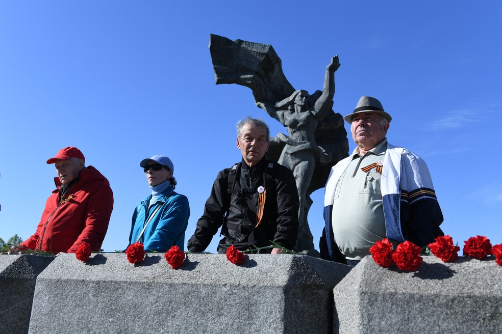 Turistas posam na frente do monumento da vitória em Riga, na Letônia — Foto: ILMARS ZNOTINS / AFP