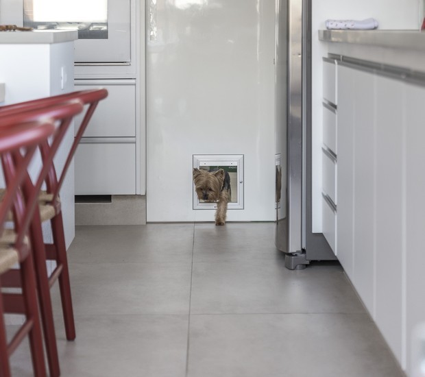 Nesse projeto do Korman Arquitetos, a passagem entre a área de serviço para a cozinha foi adaptada para o pet (Foto: JP Image / Divulgação)