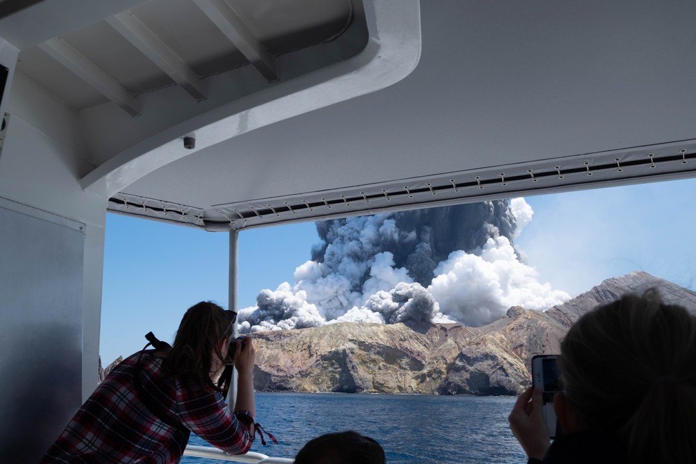 9 de dezembro - Turistas fotografam o vulcão da Ilha Branca, na Nova Zelândia, logo após o início da erupção. No momento da erupção, 47 pessoas estavam no local. Seis pessoas morreram, 8 estão desaparecidas e 31 foram levadas para o hospital, sendo pelo menos 25 em estado grave — Foto: Michael Schade