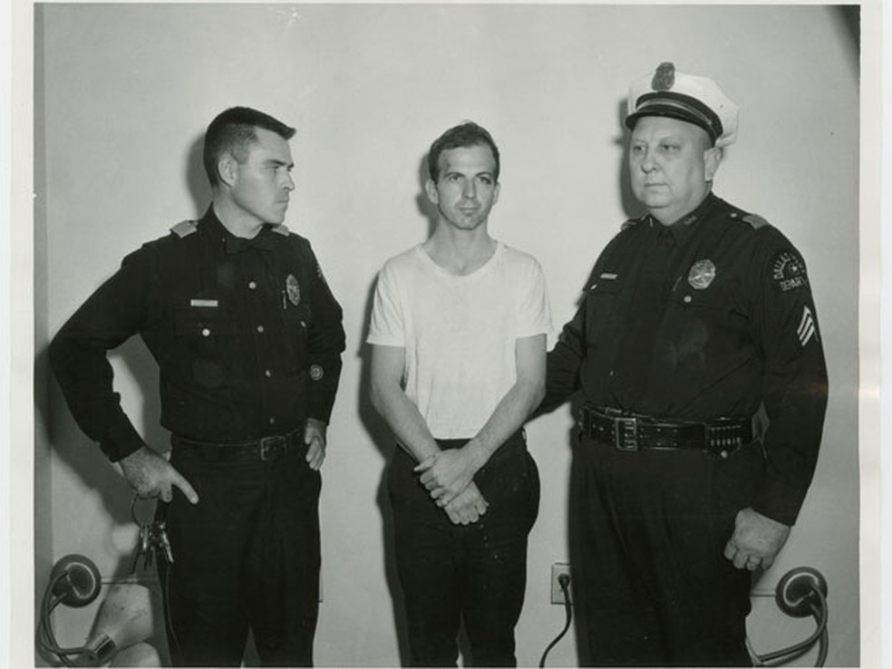 Lee Harvey Oswald, acusado de matar JFK, ao lado de policiais após ser preso no dia 22 de novembro de 1963 (Foto: Dallas Police Department/Dallas Municipal Archives/University of North Texas/Reuters)