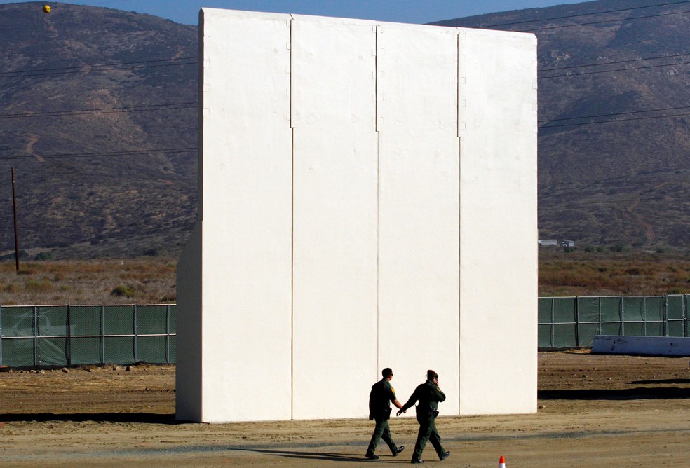 Guardas de patrulha da fronteira dos EUA caminham perto de um protótipo do muro que o presidente dos EUA Donald Trump pretende colocar na fronteira com o México nesta foto tirada do lado mexicano da fronteira, em Tijuana — Foto: Jorge Duenes/Reuters