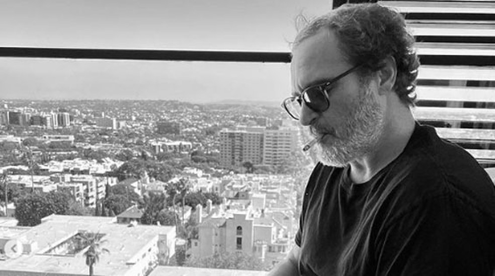 Joaquin Phoenix lê roteiro de 'Coringa 2' em foto postada pelo diretor Todd Phillips — Foto: Reprodução/Instagram