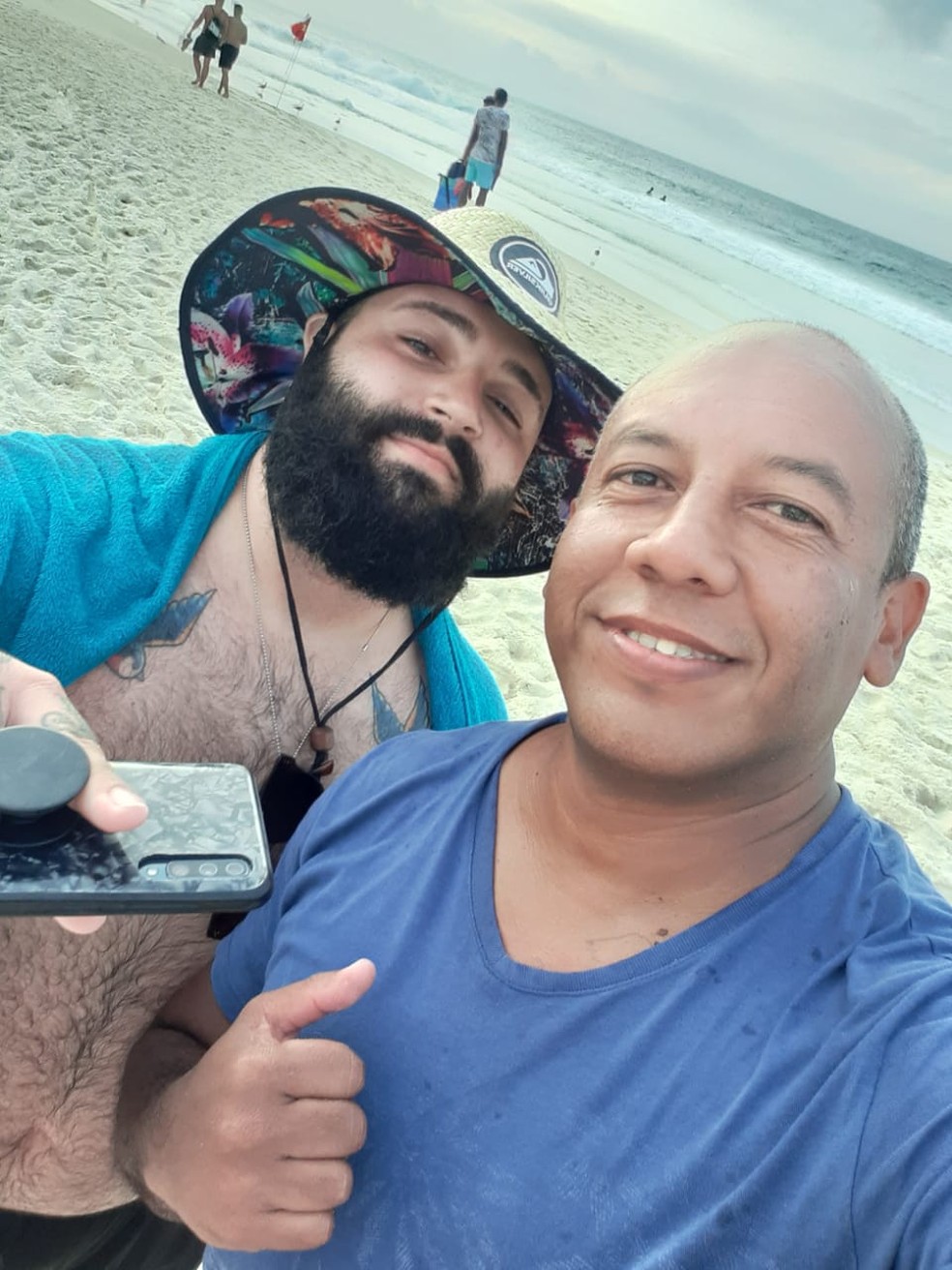 PM Almir (de azul), com o empresário Murilo Costa Pegoraro, em praia do Rio de Janeiro — Foto: Arquivo Pessoal