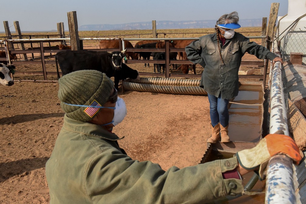 Maybelle e Leonard Sloan dão água ao gado — Foto: Stephanie Keith/Reuters