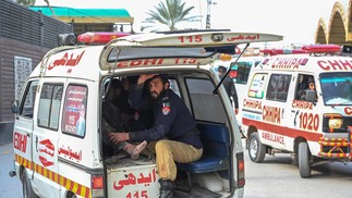 Ambulância transporta vítimas de explosão feridas fora da sede da polícia em Peshawar, Paquistão — Foto: ABDUL MAJEED/AFP