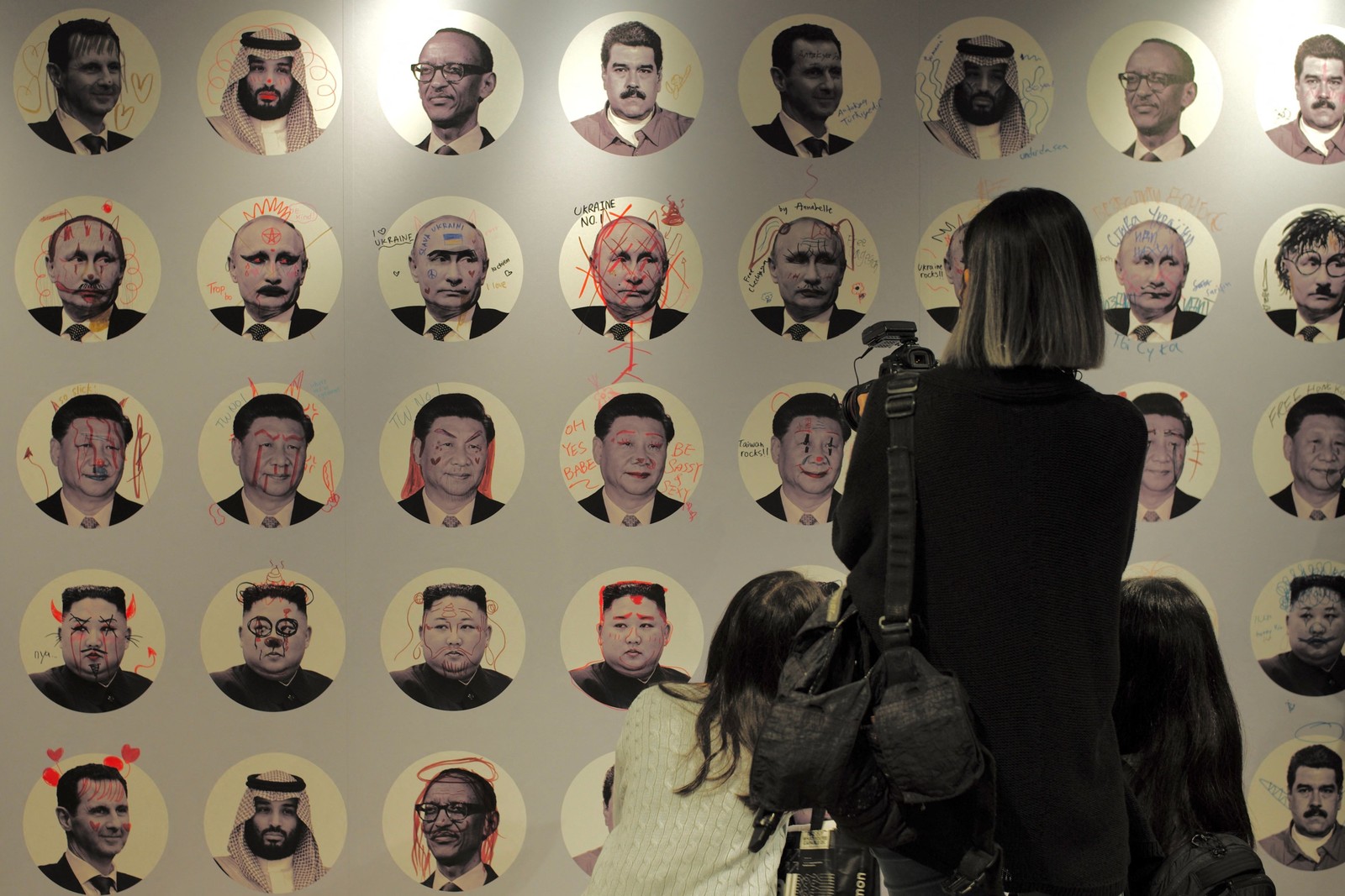 Painel com marcas de rabiscos em retratos de vários ditadores é visto durante o Fórum da Liberdade de Oslo, Taipei — Foto: Sam Yeh / AFP