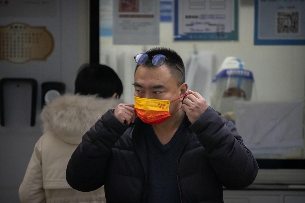 A man adjusts his face mask after taking a COVID-19 test at a coronavirus testing site in Beijing, Friday, Nov. 18, 2022. Chinese authorities faced more public anger Thursday after a second child's de — Foto: Mark Schiefelbein/AP