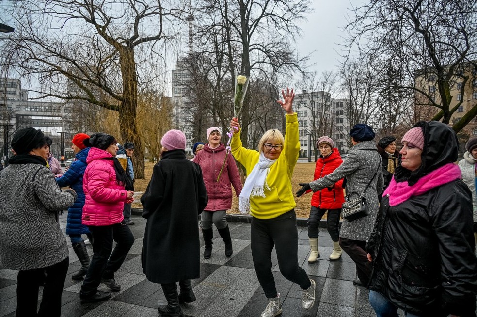 Na Ucrânia, as mulheres dançam para marcar o Dia Internacional da Mulher na Freedom Square, em Kharkiv, em 8 de março de 2023, em meio à invasão russa. — Foto: SERGEY BOBOK / AFP