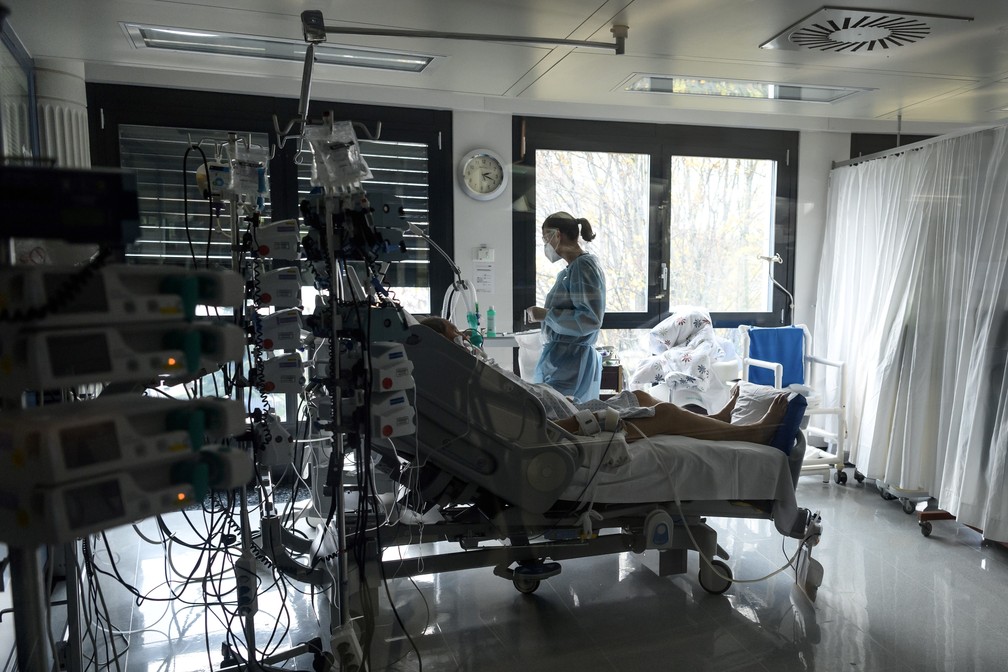 Profissional de saúde monitora paciente em UTI para casos de Covid-19 em hospital em La Chaux-de-Fonds, oeste da Suíça, na quinta-feira (5).  — Foto: Fabrice Coffrini / AFP