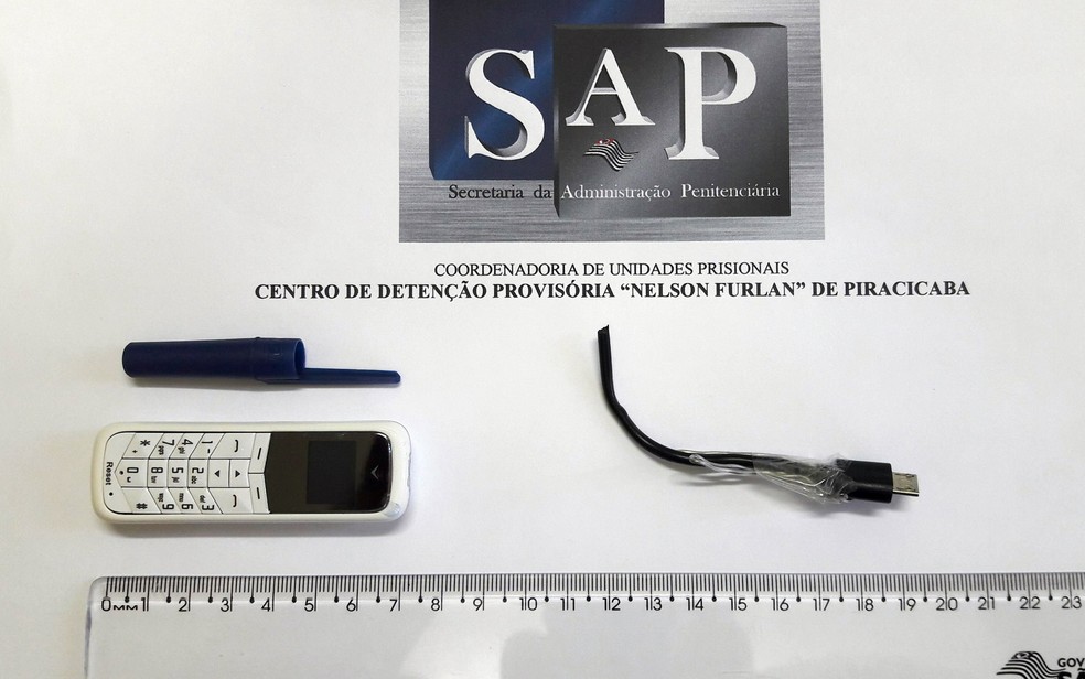 Celular e pedaço de fio de carregador apreendido com visitante do CDP de Piracicaba (Foto: Divulgação/SAP)