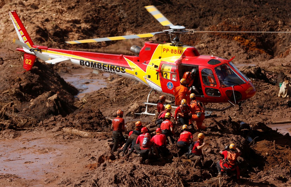 Membros do corpo de bombeiros procuram por sobreviventes na lama em Brumadinho — Foto: Adriano Machado/Reuters
