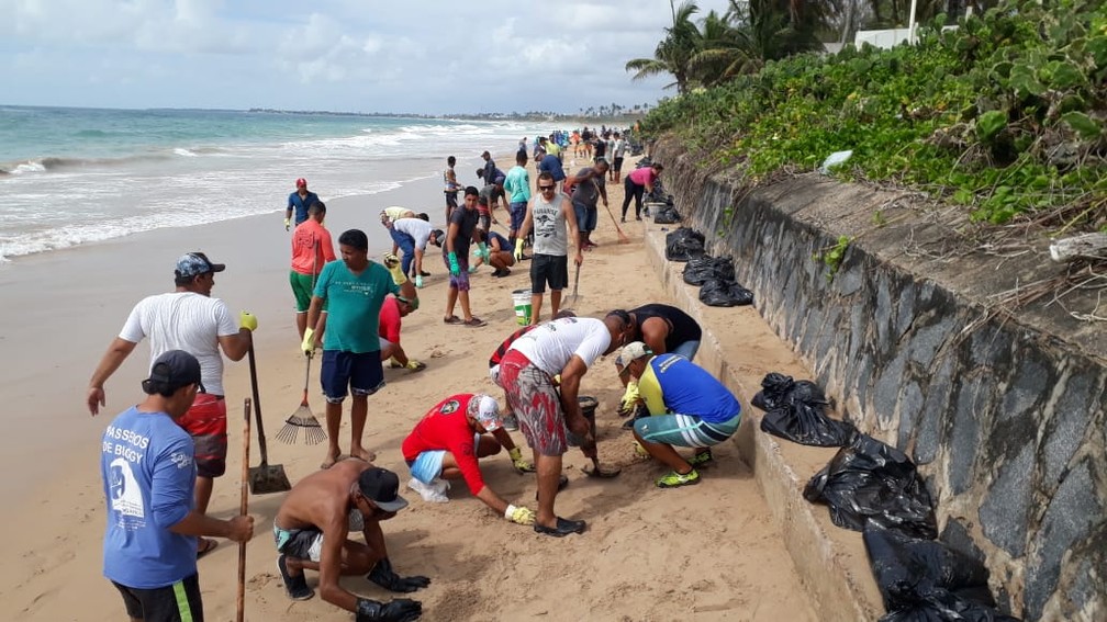 Voluntários limpam óleo encontrado na Praia do Cupe, em Ipojuca, neste sábado (19) — Foto: Wellignton Pereira/TV Globo