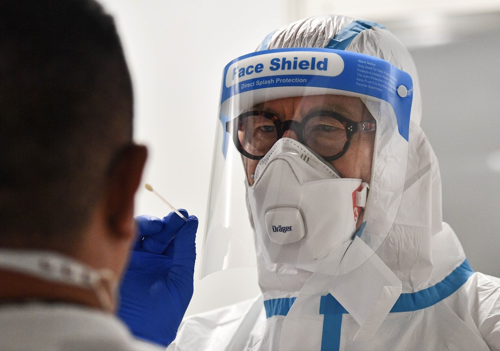 M&eacute;dico faz teste de covid-19 em um passageiro no aeroporto de D&uuml;sseldorf, Alemanha, segunda-feira, 27 de julho de 2020 &mdash; Foto: Martin Meissner/AP