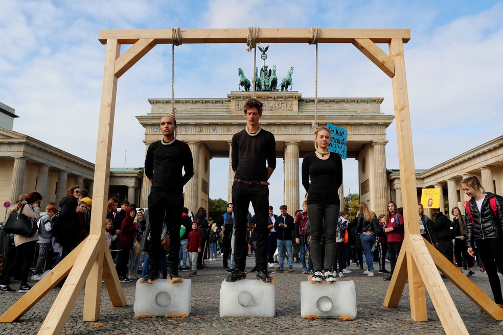 Greve pelo Clima: Na Alemanha, ativistas sobem em blocos de gelo sob forca improvisada em frente ao portão de Brandemburgo, em Berlim, Alemanha, para alertar sobre os riscos do aquecimento global — Foto: Fabrizio Bensch/Reuters