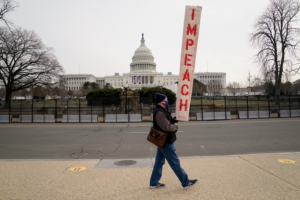 Manifestante carrega um cartaz pedindo pelo impeachment em frente ao Capitólio dos EUA em foto de 11 de janeiro de 2021 — Foto: Erin Scott/Reuters