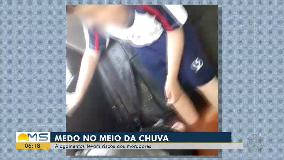 Menino em pé no banco traseiro com água nas pernas — Foto: Reprodução/TV Morena