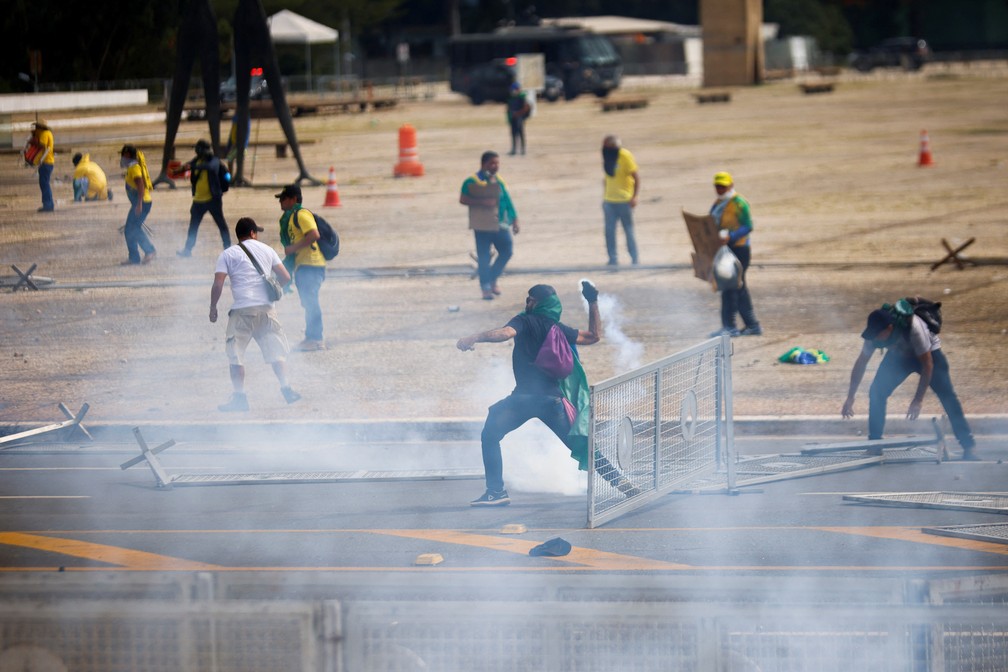 Homem atira de volta uma bomba de gás lacrimogêneo contra policiais na Praça dos Três Poderes, em Brasília — Foto: Adriano Machado/Reuters