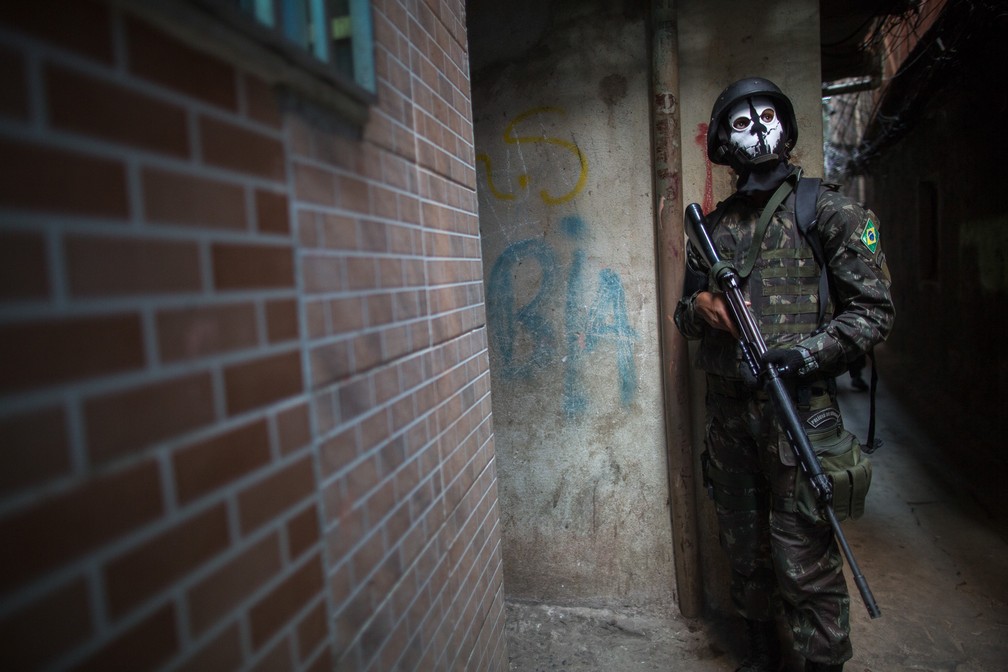 Um soldado do exército patrulha um beco na favela da Rocinha, no Rio de Janeiro, nesta segunda-feira (25) (Foto: Mauro Pimetel/AFP)