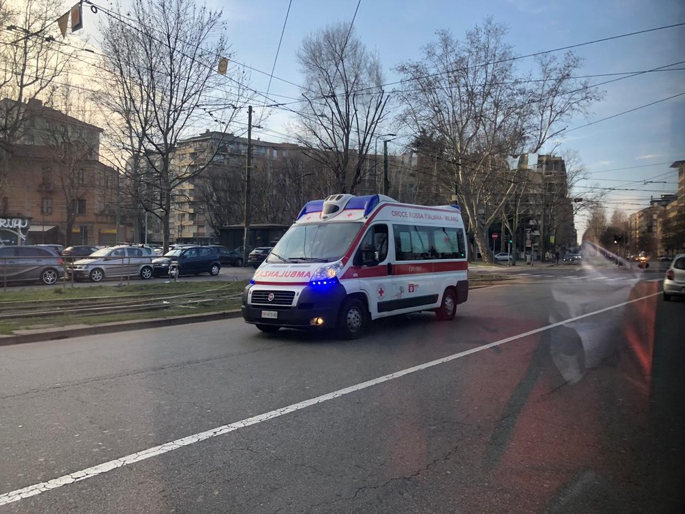 Passageiros de ônibus em Milão usam máscaras enquanto uma ambulância é vista passando, no domingo (24). — Foto: Diego Guichard/Arquivo pessoal