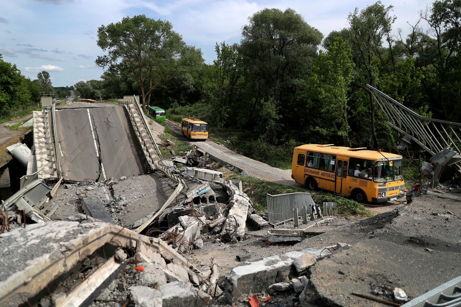 Comboio de evacuação viaja da cidade de Kupiansk ocupada por tropas russas, ao longo de uma estrada danificada, nos arredores de Kharkiv, Ucrânia